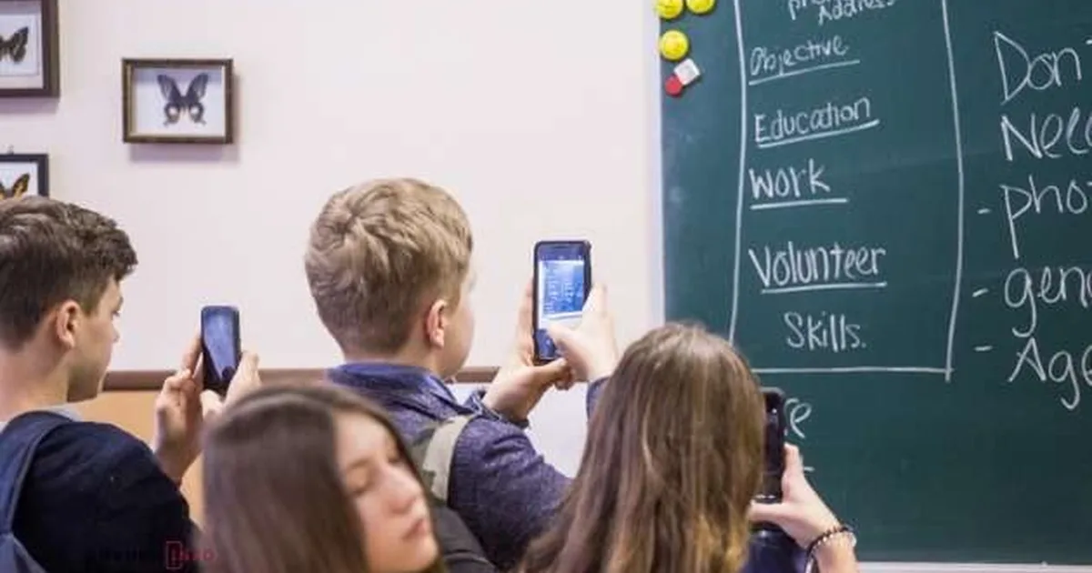 Школярі фотографують на смартфони конспект на класній дошці